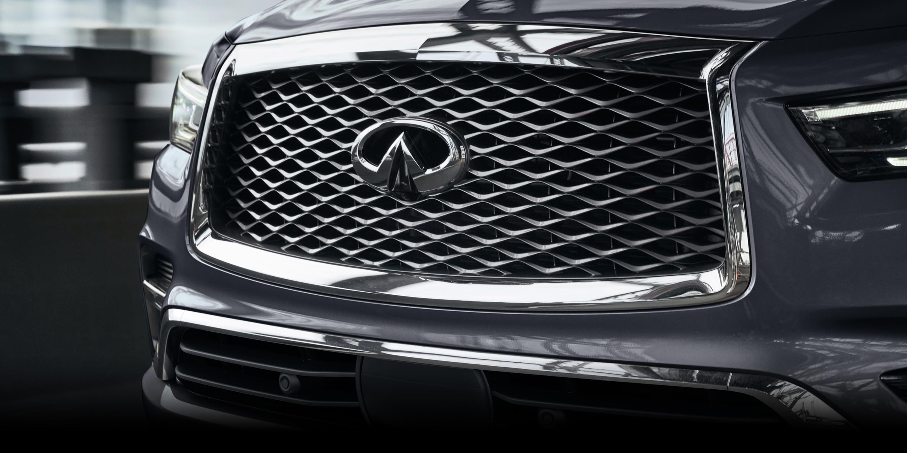 Close-up of the 2022 INFINITI QX80 SUV front grille and logo.